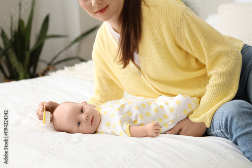 Mother brushing her little ...
