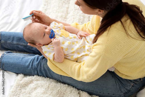 Mother brushing her little ...