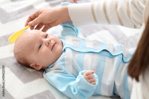 Woman combing her little ba...