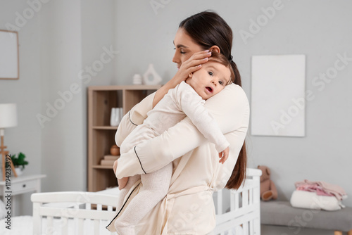 Young mother in pajamas hug...