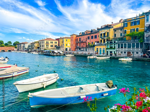 landscape of Peschiera del Garda in the province of Verona in Veneto, Italy. The main canal in a town on Garda Lake. Sunset view of Canale di Mezzo in Italian town Peschiera del Garda.