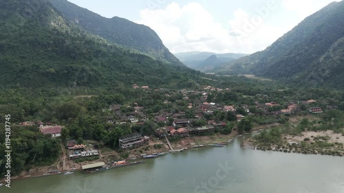 Drone footage along the quiet village of Muang Ngoy in Luang Prabang province, Laos. Surrounded by karst mountains and green vegetation, time seems stopped there... photo