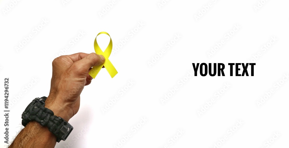 male hand holding yellow ribbon isolated on white background. concept of support and resistance against cancer disease male hand holding yellow ribbon isolated on white background. concept of support and resistance against cancer disease
