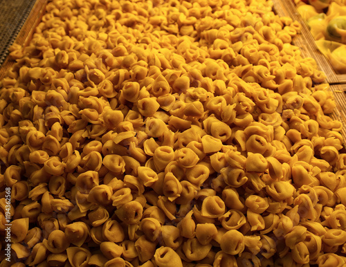 Obraz na płótnie Close-up of a large pile of fresh Italian tortellini pasta in a display case. w salonie