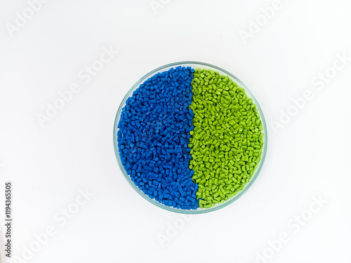 Colorful masterbatch plastic granules in transparent glass cup, polymer carrying pigment poured in white background, suitable for product catalog design of plastic manufacturing industry company profi photo