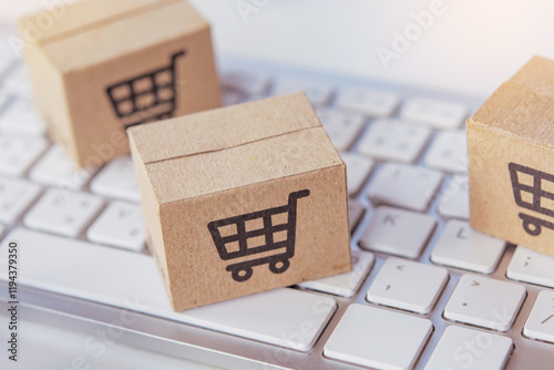 Shopping online. Cardboard box with a shopping cart logo on laptop keyboard. Shopping service on The online web. offers home delivery