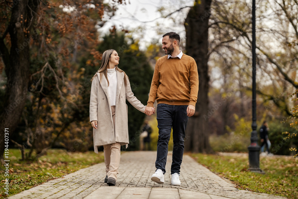 Happy romantic couple in love holding hands and walking in city park. Happy romantic couple in love holding hands and walking in city park.