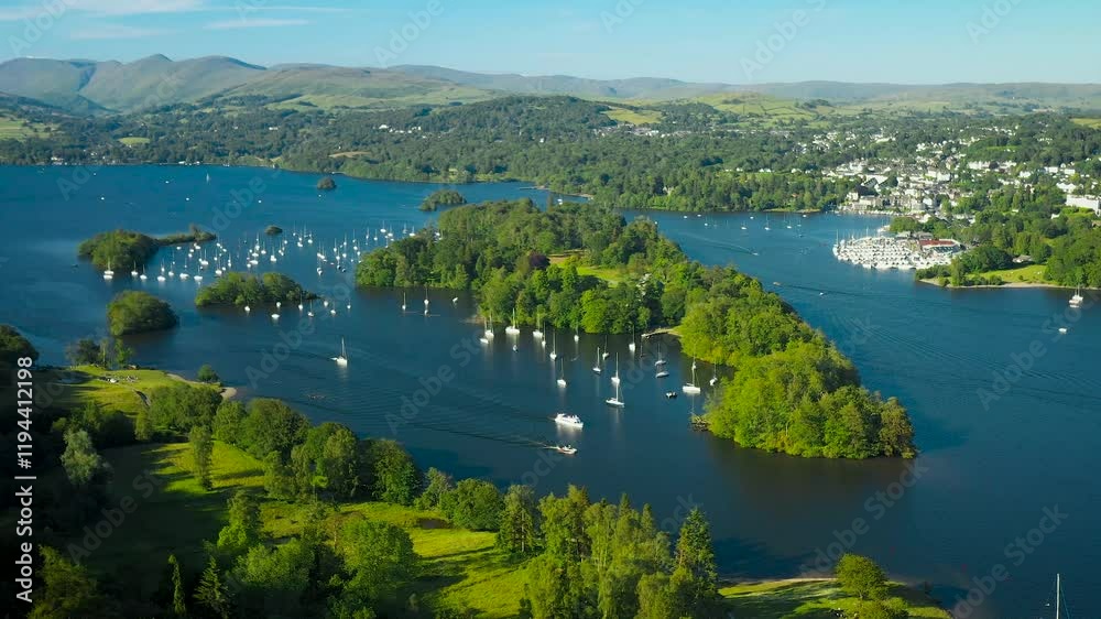 Windermere in the Lake District National Park, Cumbria, England. Aerial video fly in to N.E. over Belle Isle to Bowness marinas. Summer evening