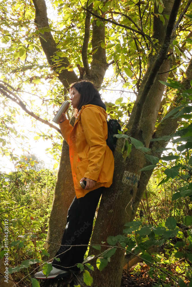 Woman enjoying nature with tea on a forest trail Woman enjoying nature with tea on a forest trail