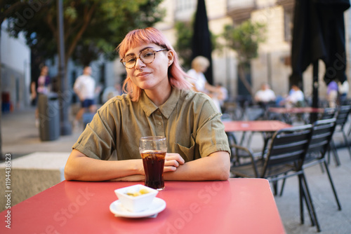 Young woman enjoying a refreshing drink and snack at outdoor cafe