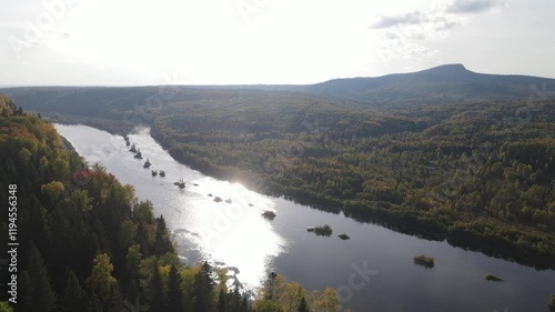 Flight over a sunny autumn forest and river