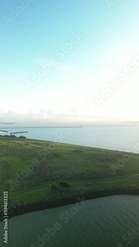 Aerial perspective of Cesar Chavez Park in Berkeley, California, showcasing the Berkeley Marina breakwater under a serene gradient sky, creating a tranquil coastal landscape photo