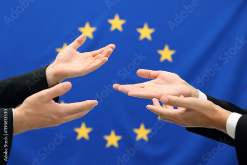 Diplomats negotiating during meeting against flag of European Union, closeup photo