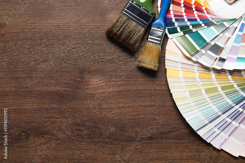 Fototapeta Naklejka Na Ścianę i Meble -  Color selection charts and paint brushes on wooden table, flat lay with space for text. Decorating and design