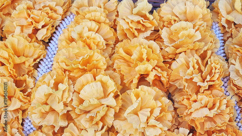 Photograph of plastic flowers placed on white stones at a square table during a ceremony in a temple in Central Thailand 