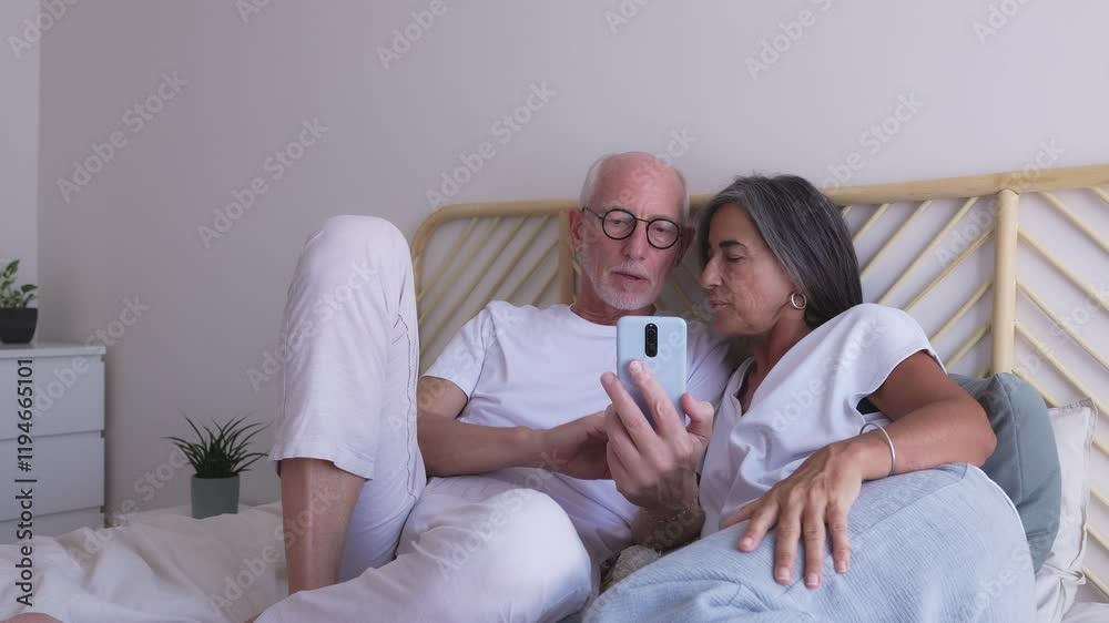 Senior couple browsing smartphone in bed: slow motion montage Senior couple browsing smartphone in bed: slow motion montage