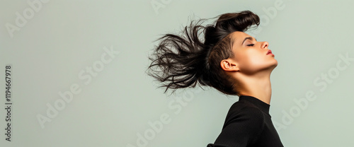 Studio portrait of punk woman with mohawk haircut and movement, neutral background photo