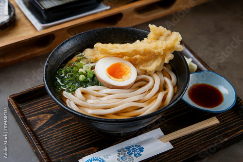 tasty and healthy udon or ramen noodle soup with egg yolk and leek, tempura or tenpura, soba, miso, traditional japanese cuisine, restaurant, close up