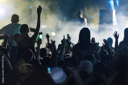Photos Silhouetted crowd enjoying concert under colorful lights