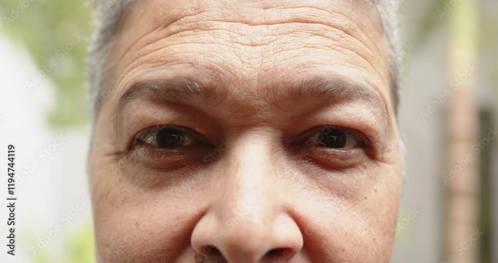 Close-up of person's face with neutral expression, focusing on features, at home