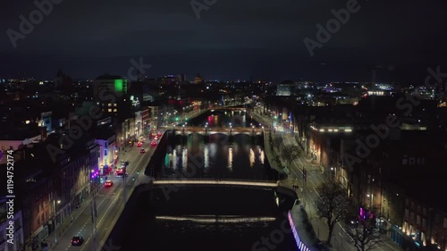 Establishing drone shot of Dublin City centre at night, flying over the river Liffey