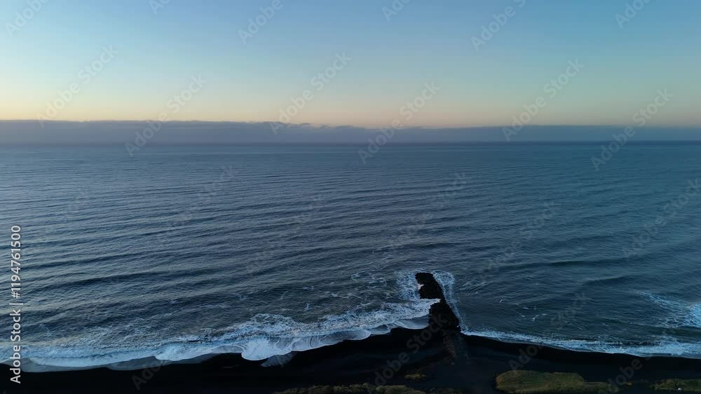 A captivating aerial view of the black sand beach with soft white waves lapping against the shore, the calm ocean stretching into the horizon, and the early morning sky providing a serene backdrop. A captivating aerial view of the black sand beach with soft white waves lapping against the shore, the calm ocean stretching into the horizon, and the early morning sky providing a serene backdrop.