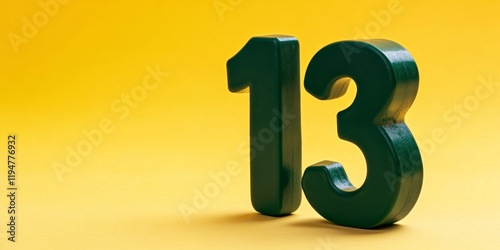 Green plastic number thirteen toy in lower right corner on vibrant yellow backdrop showcasing playful educational concept for children photo