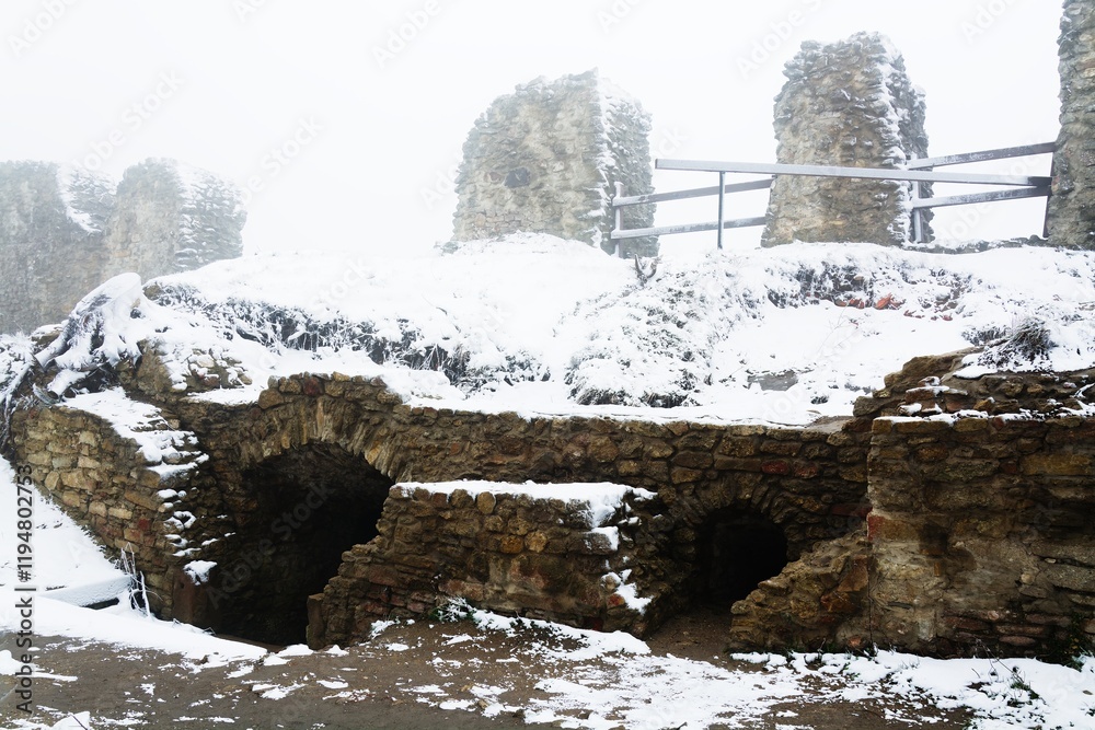 Entrance to the underground spaces of the upper courtyard of the castle ruins in winter. Stary Jicin. Moravia. Czechia.