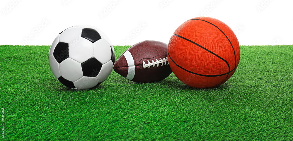 Different balls on artificial grass against white background. Sport equipment Different balls on artificial grass against white background. Sport equipment