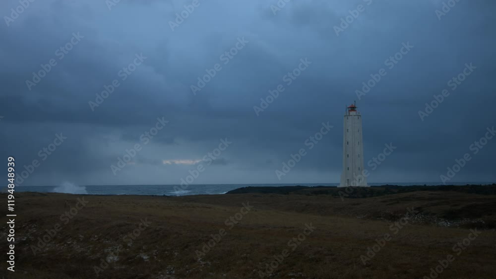 Waves crashing on the shore on a gloomy day. Stable shot with a lighthouse in the foreground. Waves crashing on the shore on a gloomy day. Stable shot with a lighthouse in the foreground.