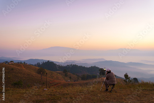 Asian woman relaxes with the beautiful natural scenery of the sea of mist in the morning at Doi Ba Lu Kho Mountain View Point, Mae Chaem, Chiang Mai, Thailand. Travel recreation background. photo