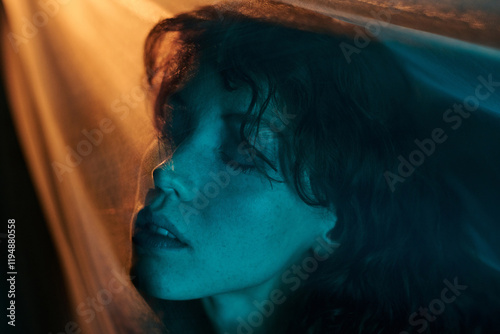 Fotografie Medium close up of attractive woman lying on veil with closed eye