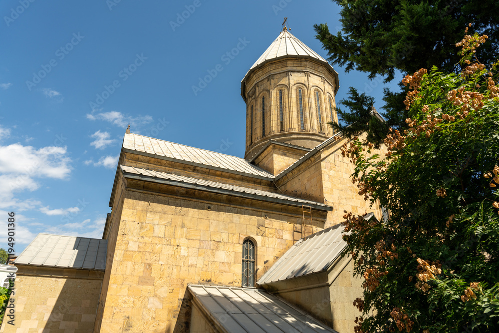 Fototapeta premium A large building with a steeple and a window. The building is brown and has a lot of detail