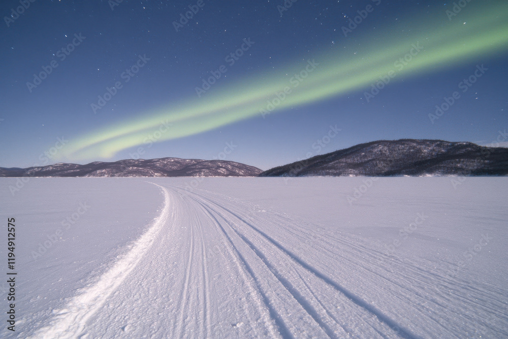 A long green light is seen in the sky above a snowy field A long green light is seen in the sky above a snowy field