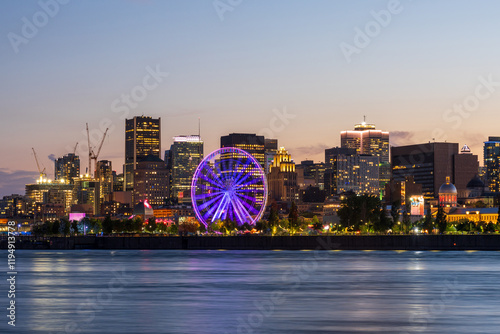 Old Port of Montreal and downtown skyline at night. Colorful buildings lights reflected in water. Montreal city, Quebec, Canada. Ferris wheel.