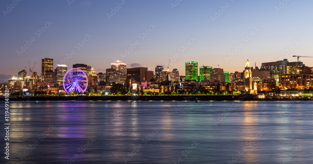 Fototapeta premium Old Port of Montreal and downtown skyline at night. Colorful buildings lights reflected in water. Montreal city, Quebec, Canada.