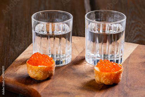 Obraz na płótnie glasses of vodka and salmon caviar appetizer on a wooden table w salonie