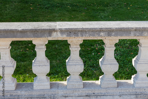 Part of stone balustrade sunlit against the lawn in shade photo