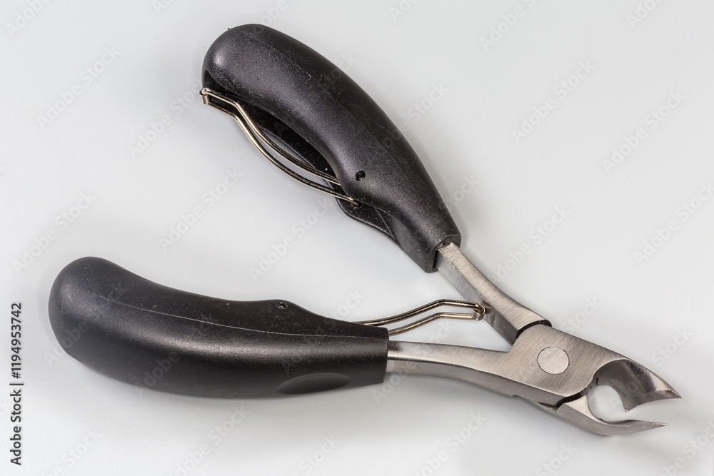 Obraz premium Professional pedicure nail clipper with curved blades on gray background