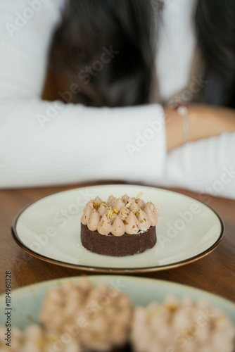Chocolate cake, served in a plate. with young beautiful Asian ladies hand background