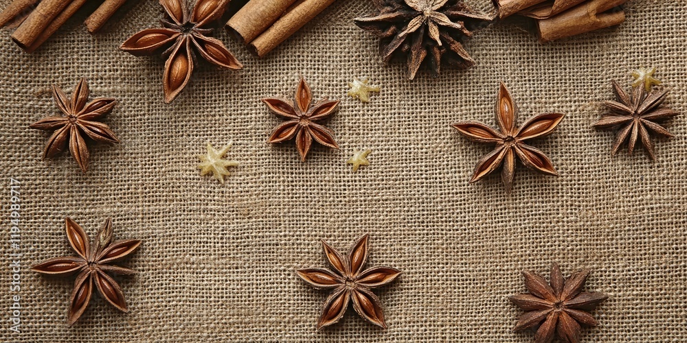 Anise stars and cinnamon sticks arranged on a natural burlap background with a warm earthy tone evoking a cozy winter holiday ambiance Anise stars and cinnamon sticks arranged on a natural burlap background with a warm earthy tone evoking a cozy winter holiday ambiance