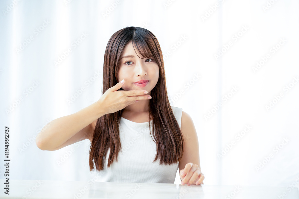 リビングで肌を触る日本人女性 リビングで肌を触る日本人女性
