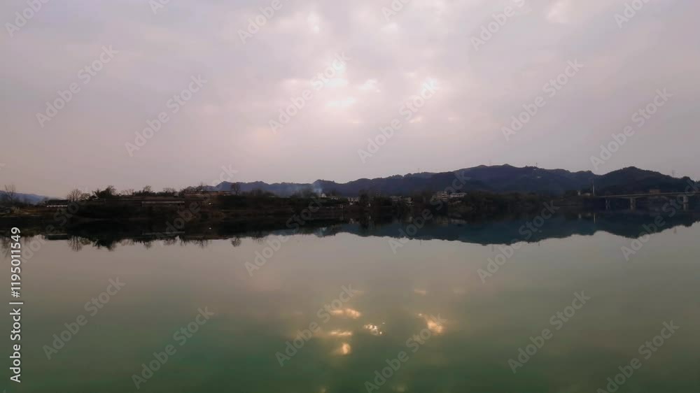 Natural beauty of a sunset reflecting light over a serene body of water with mountain backdrop in a time lapse Natural beauty of a sunset reflecting light over a serene body of water with mountain backdrop in a time lapse