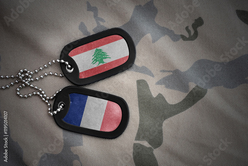 vintage army blank, dog tag with flag of lebanon and france on the khaki texture background. military concept. photo