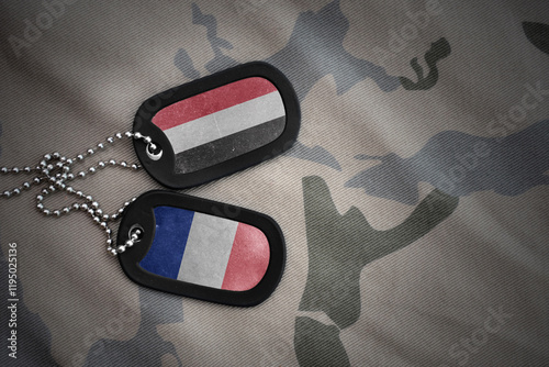 vintage army blank, dog tag with flag of yemen and france on the khaki texture background. military concept. photo