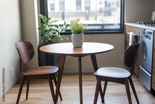 A compact dining table with a round wooden top  paired with sleek modern chairs in a small urban space