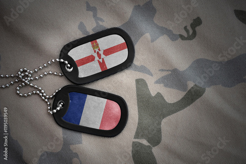 vintage army blank, dog tag with flag of northern ireland and france on the khaki texture background. military concept. photo