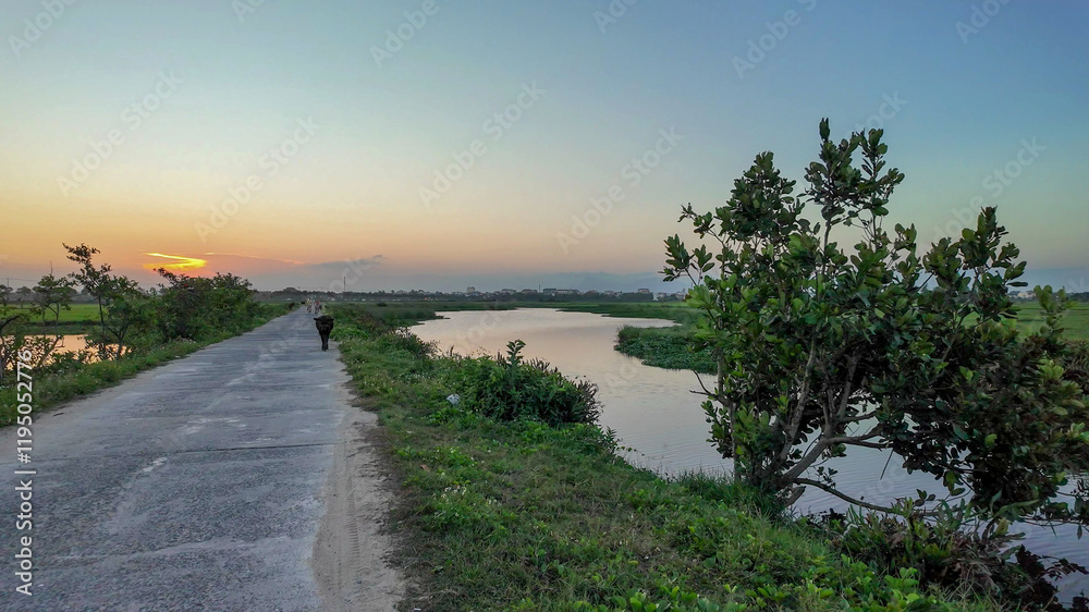 A serene rural landscape at sunset with a solitary figure on a country road, evoking tranquility and escape