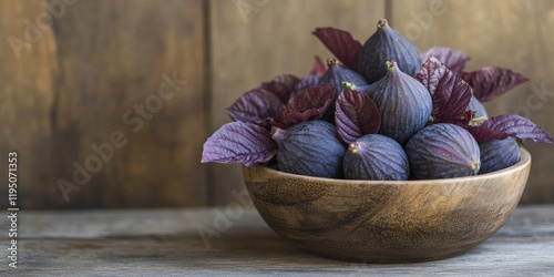 Wooden bowl filled with fresh figs and purple gynura leaves in vertical orientation against a rustic wooden background with ample copy space photo