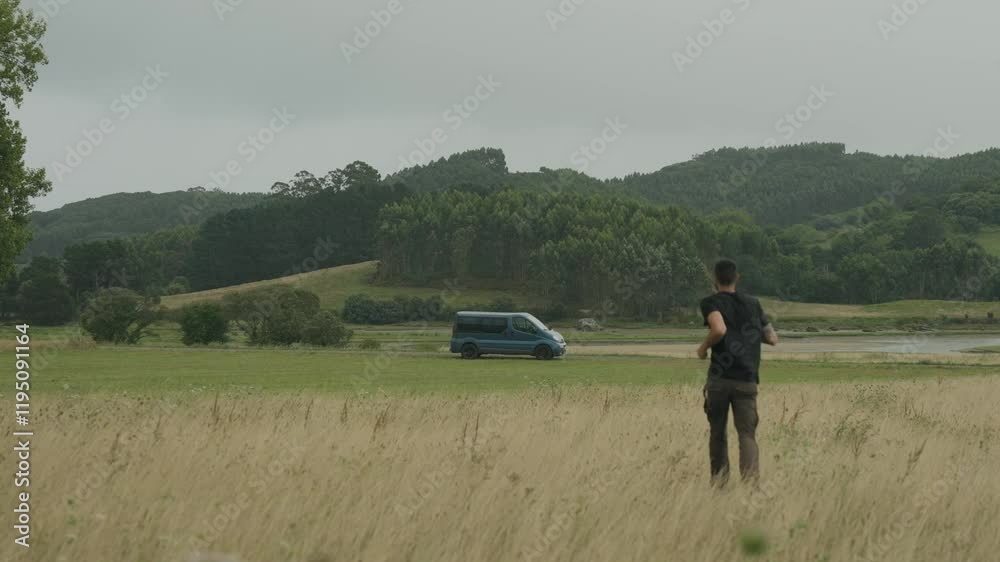 Hombre andando hacia una furgoneta en el campo Hombre andando hacia una furgoneta en el campo